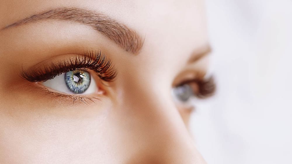 She has striking light blue or gray eyes, full and neatly shaped eyebrows, and very long, voluminous eyelash extensions.