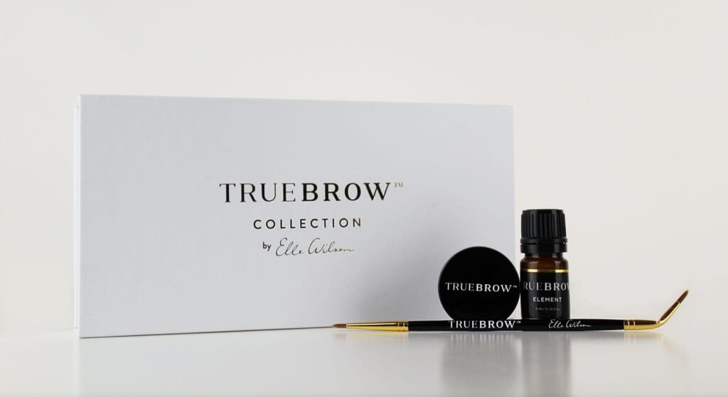 A professional beauty product flat lay featuring the "TRUE BROW COLLECTION by Elle Wilson" kit.